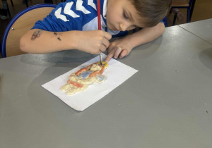 Chłopiec maluje aniołka