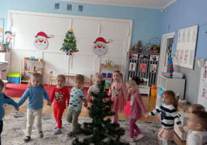 Dzieci w kole idą wokół choinki