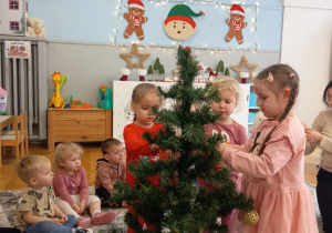 Dziewczynki zakladają bombki choinkowe