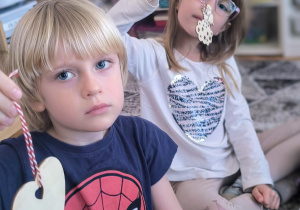 Dzieci pokazują drewniane bombki choinkowe