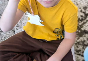 Chłopiec pokazuje drewnianą bombkę dzwoneczek