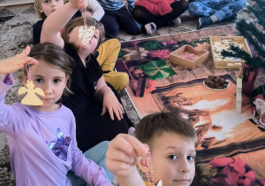 Dzieci pokazują bombki drewniane