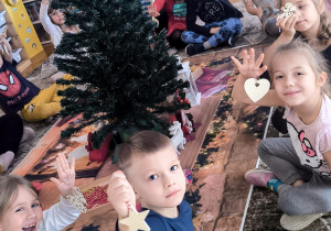 Dzieci pokauzją bombki choinkowe drewniane