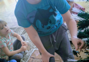 Chłopiec zakłada bombkę na choinkę