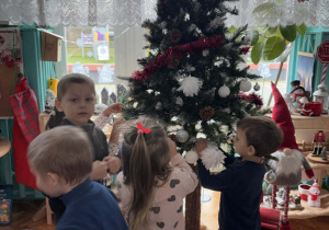Dzieci ubierają choinkę