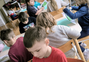 Dzieci wycinają zielone choinki