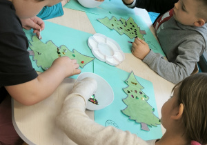 Dzieci przy stoliku wybierają kolorowe cekiny