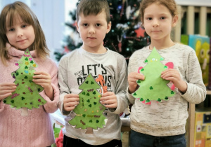 Dzieci ze swoimi zielonymi cekinowymi choinkami