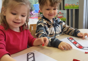 Dzieci wyklejają cukrową laskę na czerwono