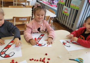 Dzieci wyklejają cukrową laskę na biało