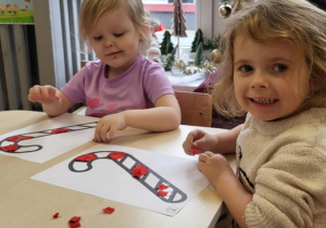 Dziewczynki wyklejają cukrową laskę bibułą