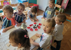 Dzieci stoja przy stoliku