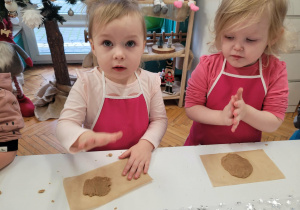 Dziewczynki przy stole wałkują ciasto