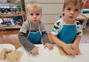 Chłopcy rozgniatają ciasto na pierniki