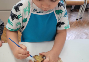 Chłopiec smaruje lukrem ciastko