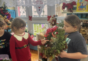 Dziewczynka pokazuje co jest w stroiku bożonarodzeniowym