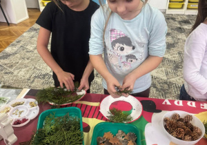 Dziewczynka przykleja małe gałązki