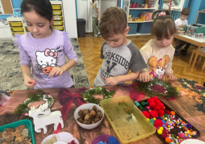 Dzieci przyklejają gałazki zielone