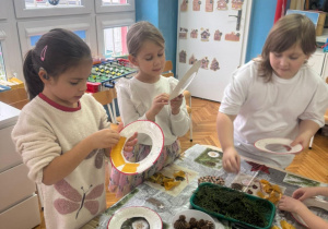 Dziewczynki odklejaja papier z taśmy dwustronnej