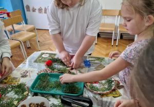 Dziewczynka doczepia dekoracje z formie gwiazdki