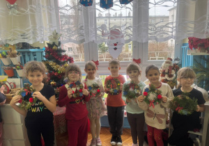 Grupa dzieci pokazuje swoje wianki bożonarodzeniowe