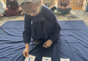 Dziewczynka kładzie cyfrę trzy