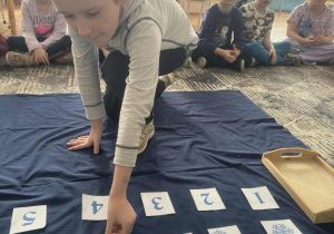 Chłopiec kładzie kartonik z czterema śnieżynkami