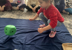 Dziewczynka rzuca kostką