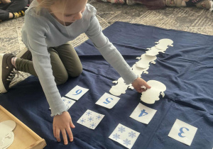 Dziewczynka kładzie cztery bałwany