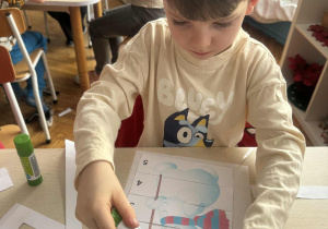 Chłopiec przykleja puzzle