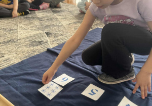 Dziewczynka kąłdzie kartonik z sześcioma śnieżynkami