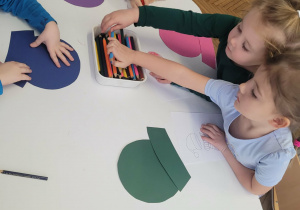 Dzieci przy stoliku kolorują obrazek