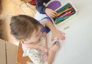 Dzieci kolorują obrazek zimowej czapki i szalika