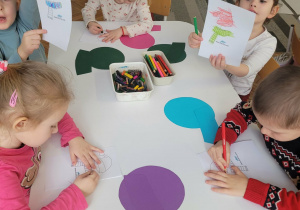 Dzieci pokazują pokolorowany szalik i czapkę