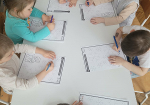 Dzieci po śladzie łączą śnieżynki