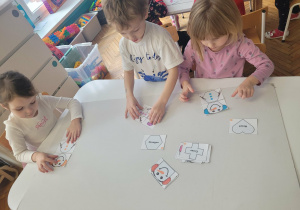 Dzieci w grupie układaja bałwanki