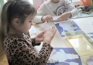 Dziewczynki z waty lepią kulki