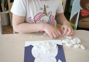 Dziewczynka robi kulki z bibuły