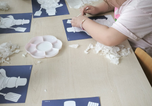 Dzieci naklejają bibułę na niebieski karton