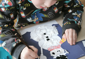 Chłopiec maluje miotłę bałwana