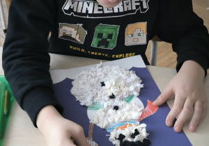 Chłopiec koloruje bałwankowi szalik