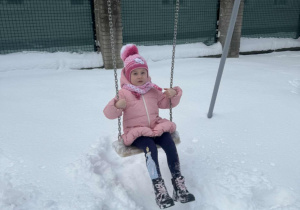 Dziewczynka buja się na huśtawce