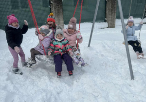 Grupa dzieci siedzi na huśtawce