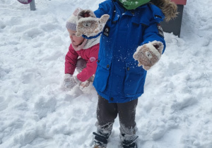 chłopiec stoi i maha do zdjęcia