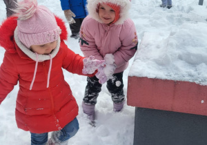 dzieci biegają w śniegu po oggrodzie przedszkolnym