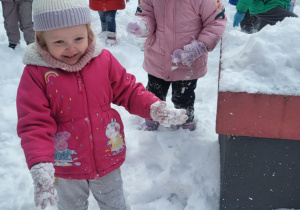 dzieci biegają w śniegu po oggrodzie przedszkolnym