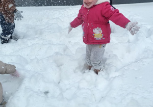 dziewczynka podrzuca śnieg