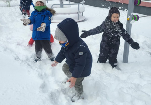 dzieci biegają po śniegu