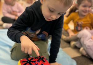 Chłopiec liczy śniezynki na kostce