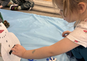 Dziewczynka wrzuca białe śniezynki